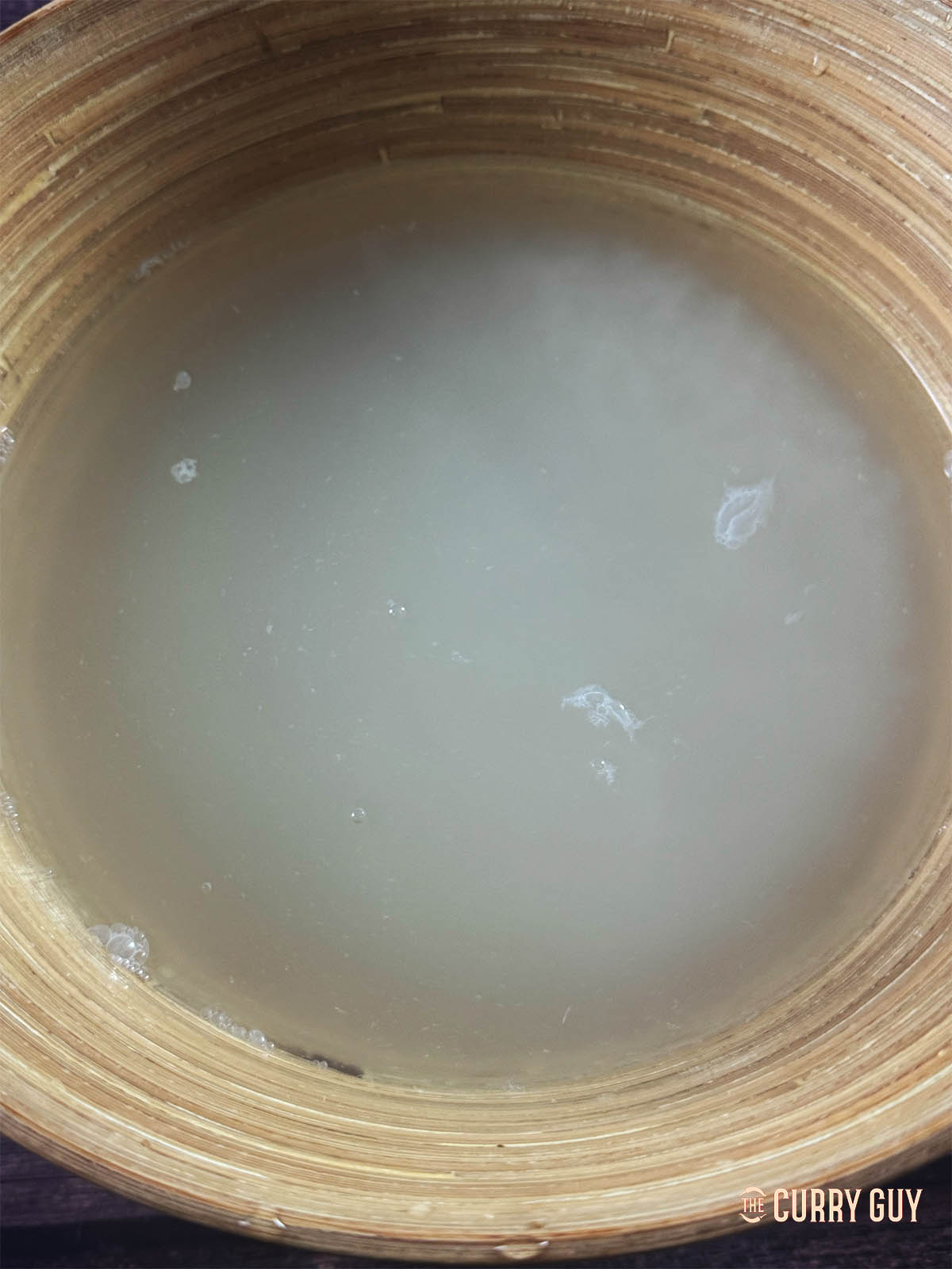 The rice in a bowl covered with water, to wash off the starch.
