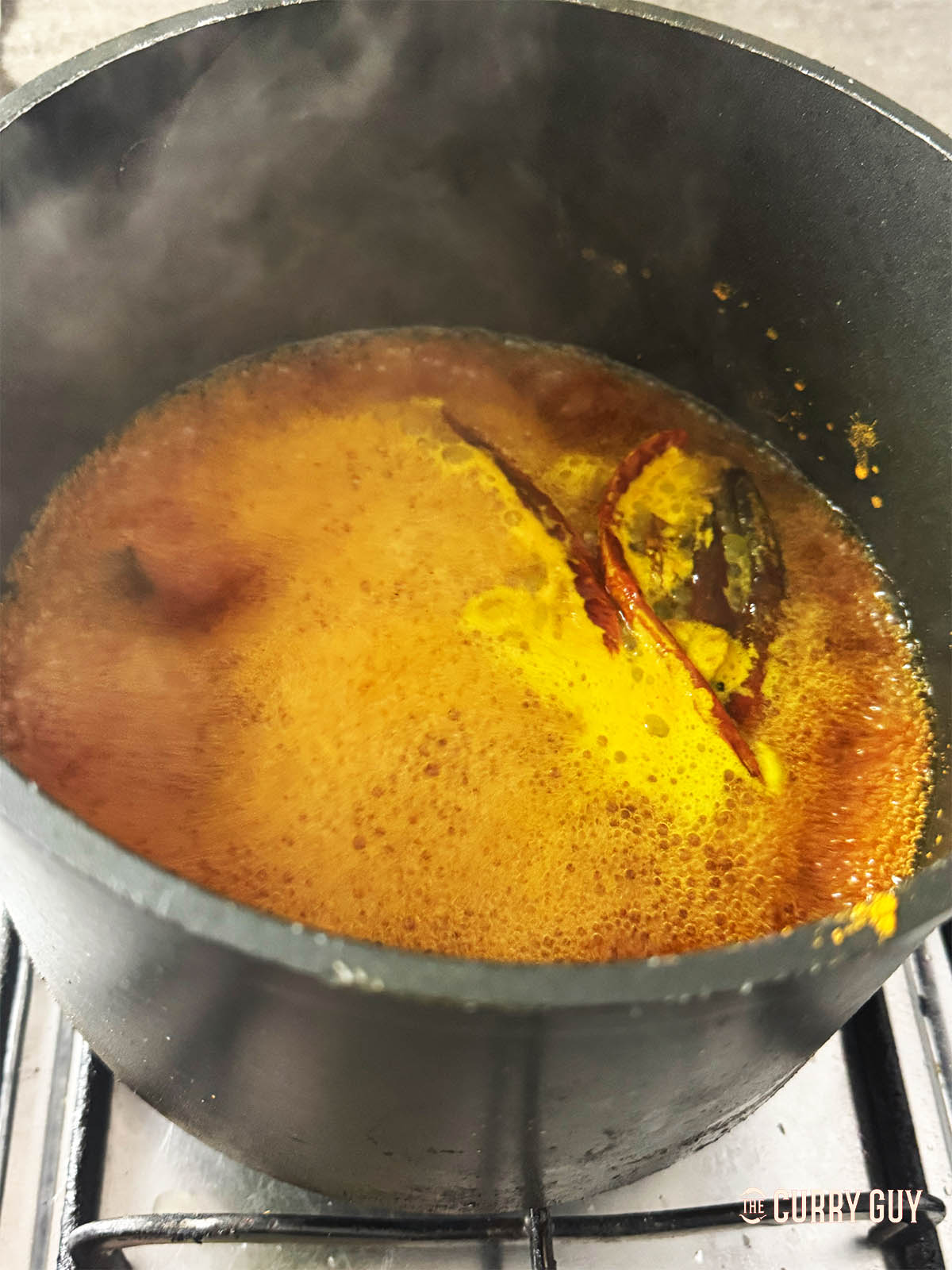 Simmering water and spices to cook the meatballs in.