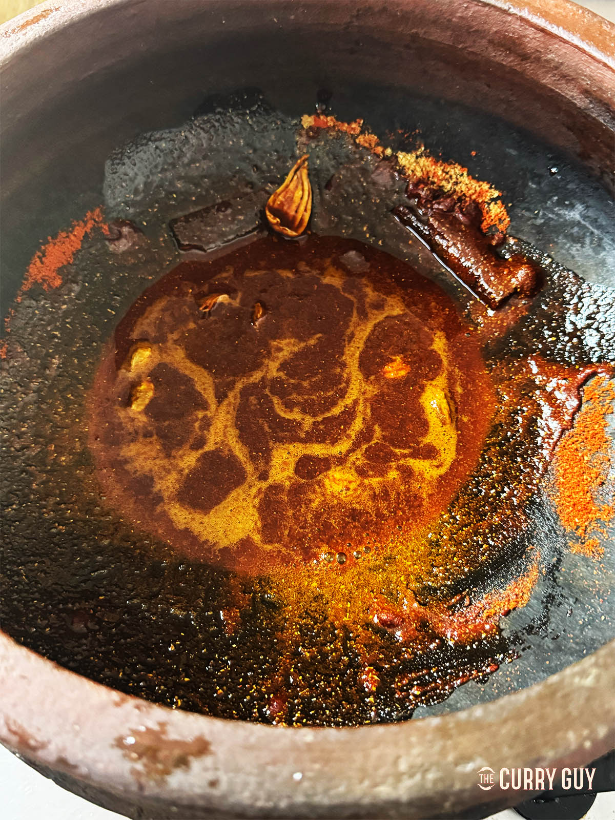 Infusing spices into oil in a clay pot. 