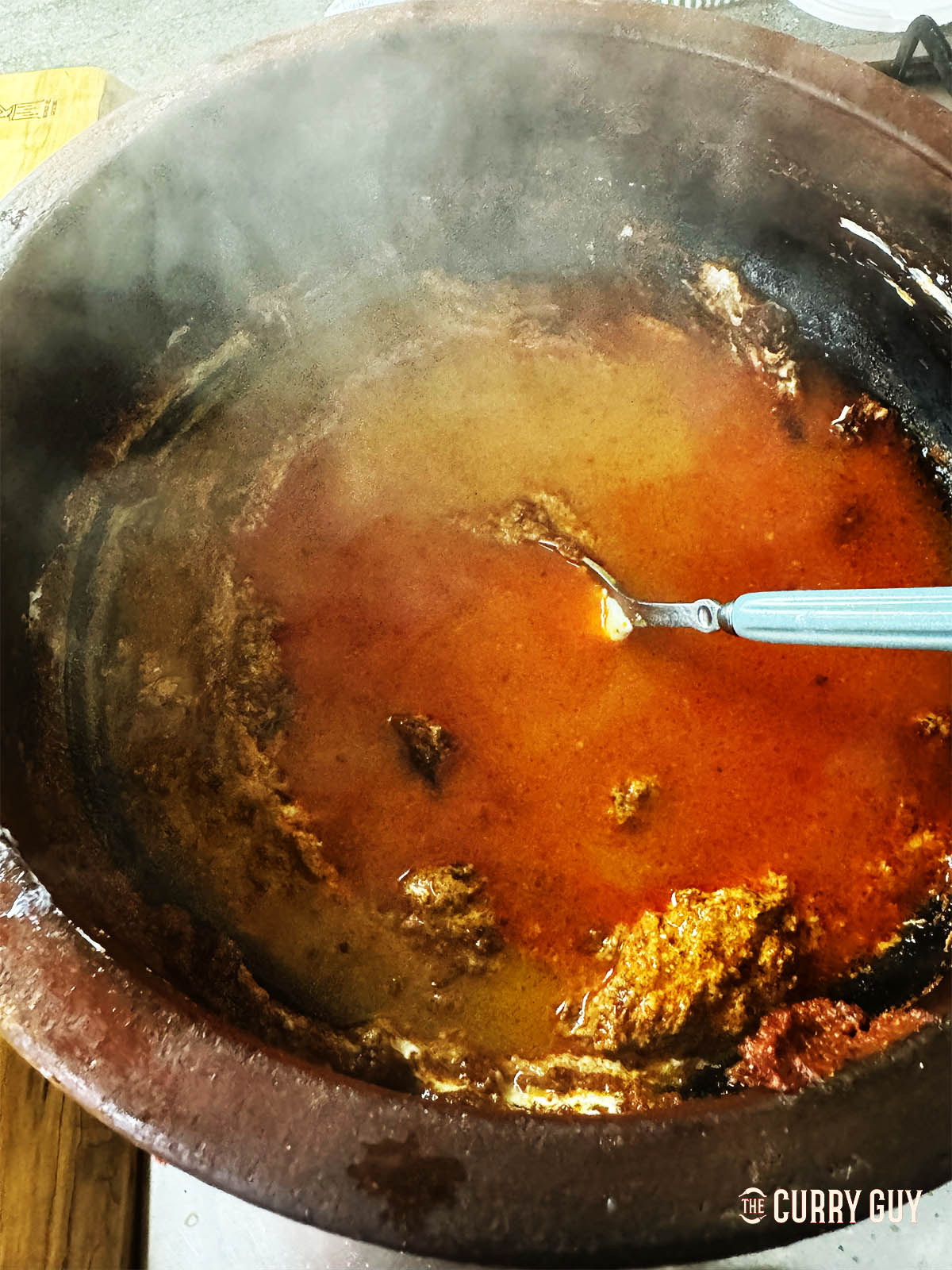 Adding water fro the simmering meatballs to the pot. 